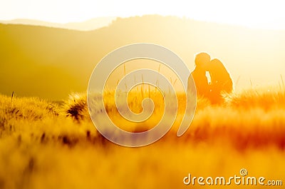 Two young people in love holding hands with shape of heart. Nature scenery, silhouette in rye, wheat field during summer sunrise Stock Photo