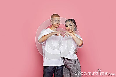 Two young people making heart. Love concept. Ypung man and woman on pink background Stock Photo