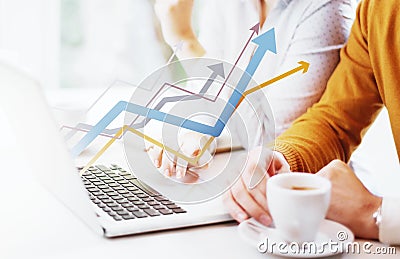 Two young people using a laptop with graphic showing growth Stock Photo