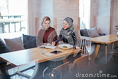 Two pretty muslim business woman in head scarf write in notebook Stock Photo