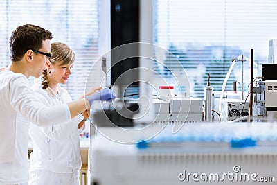 Two young researchers carrying out experiments in a lab Stock Photo