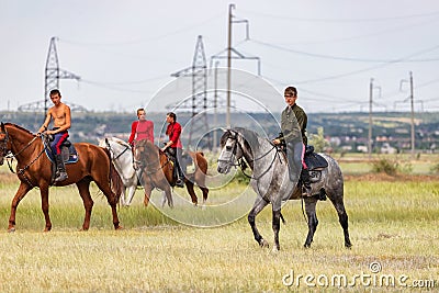Two young riders go around their horses in the field before the races Editorial Stock Photo