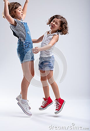 Two young sisters jumping and laughing Stock Photo
