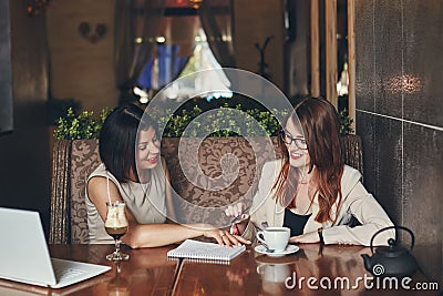 Two young smiling caucasian businesswomen with laptop. Women in cafe Stock Photo