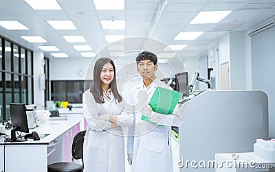 two young scientist in white lab coat standing with automation blood analyzer at medical laboratory Stock Photo