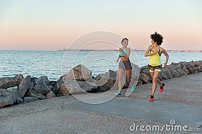 Two young sportswomen running together and talking Stock Photo