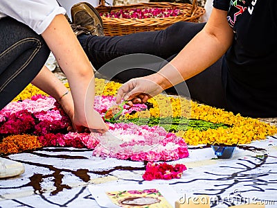 Two young street artists, working on the ground, a colorful design made of flowers Stock Photo
