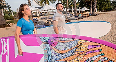 Two young surfers going into the sea with surf boards Stock Photo