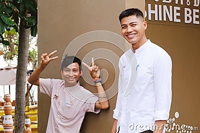 Two young Thai guys in hotel uniforms are smiling and looking at the camera Editorial Stock Photo