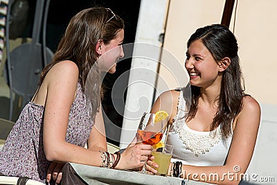 Two Young Women Cheering with Cold Drinks Stock Photo