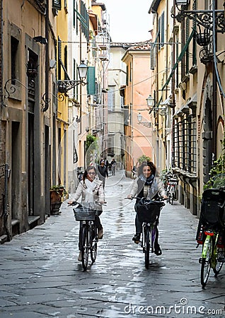 Two young women cycling in Lucca, Italy Editorial Stock Photo