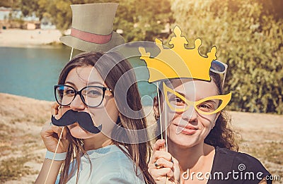 Two young women posing using photo booth props Stock Photo