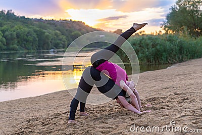 Two young women working out on a sunset beach Stock Photo