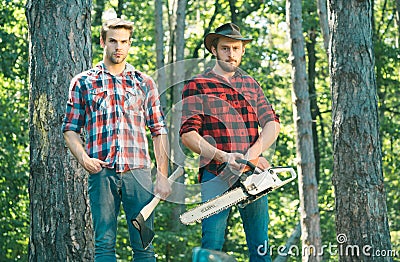 Two ypung Lumberjack man holds axe. Brutal lumberjack concept. Stock Photo