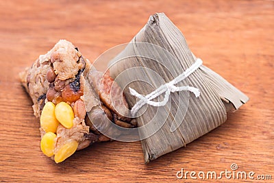 Two Zongzi or Asian Chinese sticky rice dumplings on wooden back Stock Photo