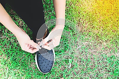 Tying sport shoes on yard, Asian woman getting ready for running, Outdoor sport, Exercise, Fitness training. Healthy lifestyle Stock Photo