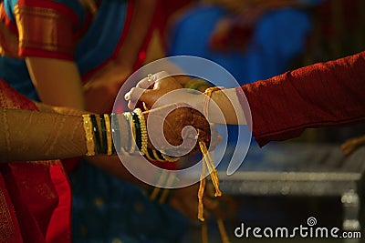 Tying wedding knot on hand of groom. Hindu marriage ritual Stock Photo