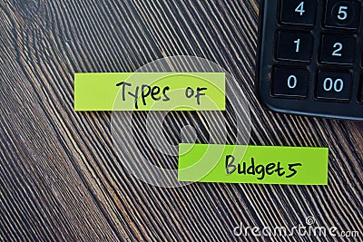 Types of Budgets write on sticky notes isolated on Wooden Table Stock Photo