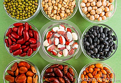 Collection of legumes in the cup isolated on green background Stock Photo