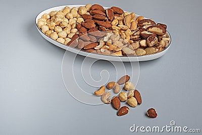 Types of roasted nuts in bowl on gray background. Immunity and healthy fats Stock Photo