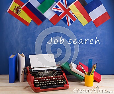 typewriter, flags of Spain, France, Great Britain, books and other countries and blackboard with text "Job search Stock Photo