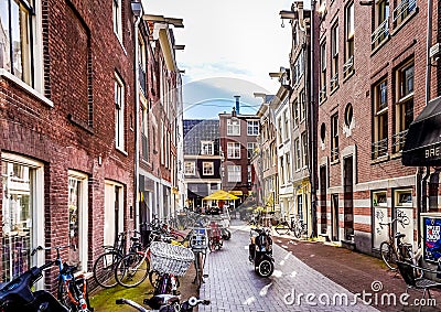 Typical Alley lined with bikes along the historic houses in the old city center of Amsterdam Editorial Stock Photo