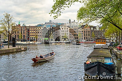 Typical Amsterdam canal with houses and floating boats in springtime, Holland Netherlands Europe Editorial Stock Photo