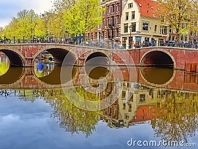 Typical Amsterdam canals with bridges and colorful boat reflection, Netherlands, Europe Editorial Stock Photo