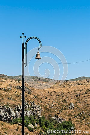 Armenia, Amberd, September 2022. Bronze bell on a pillar with a cross. Stock Photo