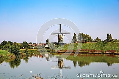 Typical beautiful idyllic dutch countryside landscape, small rural village with old windmill, lake and green meadow - Terheijden Stock Photo