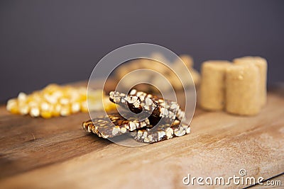 Typical brazilian June Party Festa Junina foods on a wooden table: peanuts candies paÃ§oca and pe-de-moleque corn kernels, Stock Photo