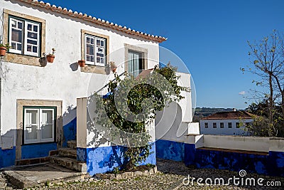 Typical brightly colored blue and white building in Obidos Portugal, a stonewalled city in a castle Stock Photo