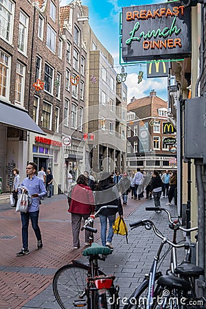 Typical city street with pedestrians below neon sign for Breakfast, lunch and Dinner and a casino on other side Editorial Stock Photo