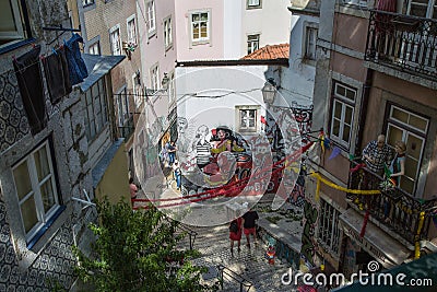 Typical Corner of Lisbon with Traditional Houses, Azulejos, Stairs, Colorful Walls and Couple of Tourists Editorial Stock Photo