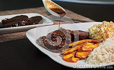 Typical dish of black roasted venezuela with chicken salad and banana Stock Photo