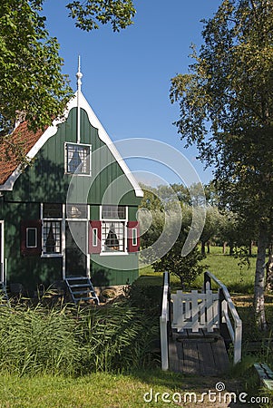 Typical Dutch architecture, green wooden house, to which the bridge leads. Editorial Stock Photo