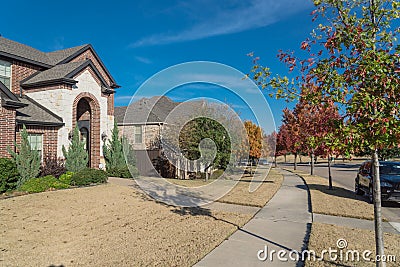 Typical front porch entrance of new suburban houses with parked car on colorful fall street outside Dallas, Texas, USA Stock Photo