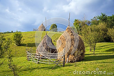 Typical hay bales and meadows of green grass and blue sky. Rural scene. Stock Photo