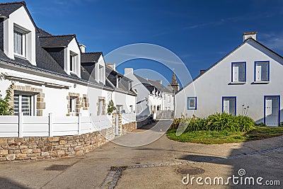 Typical houses in the village of Houat island in French Brittany. The top of Saint Gildas church is at background Stock Photo