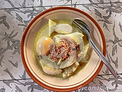 Typical Indonesian food called lontong opor, rice cake with yellow sauce and boiled eggs Stock Photo