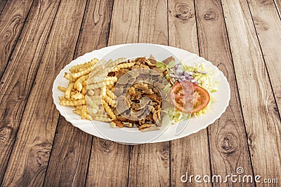 A typical kebab dish with grilled minced lamb meat on a skewer, crinkled frenc Stock Photo