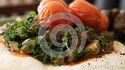 Typical Lebanese dish based on pieces of meat is roasted minced meat with a side of cooked tomatoes Stock Photo