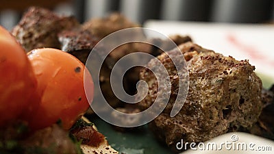 Typical Lebanese dish based on pieces of meat is roasted minced meat with a side of cooked tomatoes Stock Photo