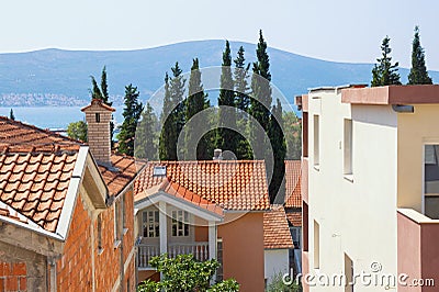 Typical Mediterranean urban landscape: houses with red tiled roof , green cypresses. Montenegro, Tivat town Stock Photo