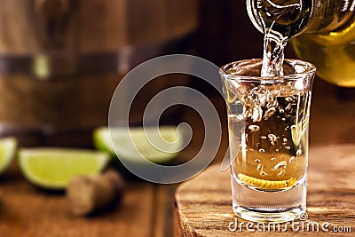 Typical mexican drink bottle filling a glass of mezcal or mescal, a rare mexican distilled beverage that contains an aphrodisiac Stock Photo