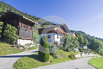 Typical mountain building in stone, white plaster and wood and with colorful flowers Stock Photo