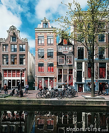 Typical narrow houses with large windows and canals with reflection, Amsterdam, Netherlands. Editorial Stock Photo