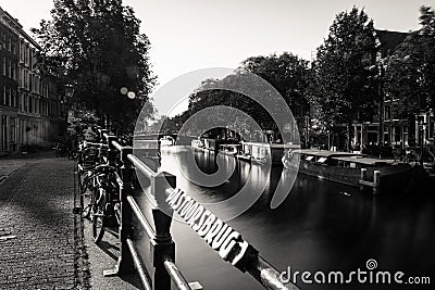 Amsterdam, Holland, the Netherlands - July 6 2020: leading line of bridge handles, sun flares showing a typical canal with Editorial Stock Photo