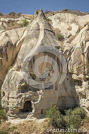 Typical stone dwelling carved in the fairy chimneys with dovecotes carved in the volcanic rock, rock hoodoo in Goreme, Cappadocia Stock Photo