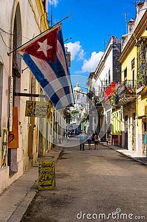 Typical street in Old Havana with a big cuban flag Editorial Stock Photo
